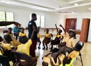 Digital skills training at a school in Ghana. The children are sitting in a circle, interacting with a teacher. 