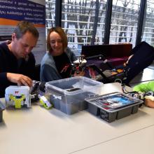 Parents and a child learning robotics skills in the library.